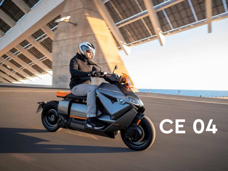 BMW CE04 electric scooter with a sleek, futuristic design parked in a modern, urban environment.