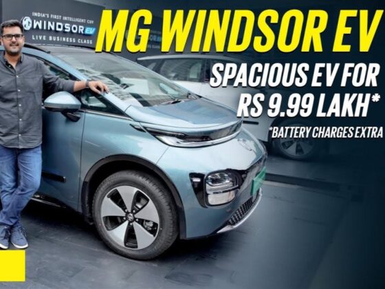 Person standing next to the MG Windsor EV, a spacious electric vehicle displayed with a price of ₹9.99 lakh, excluding battery charges.